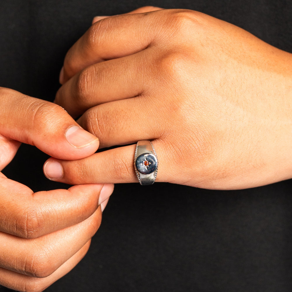 Close-up of a hand wearing a ring with a dark background