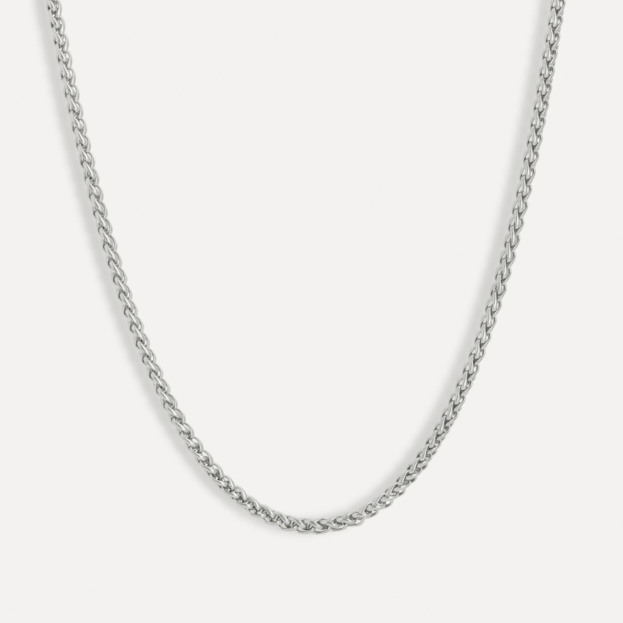 Silver chain necklace on a light gray background