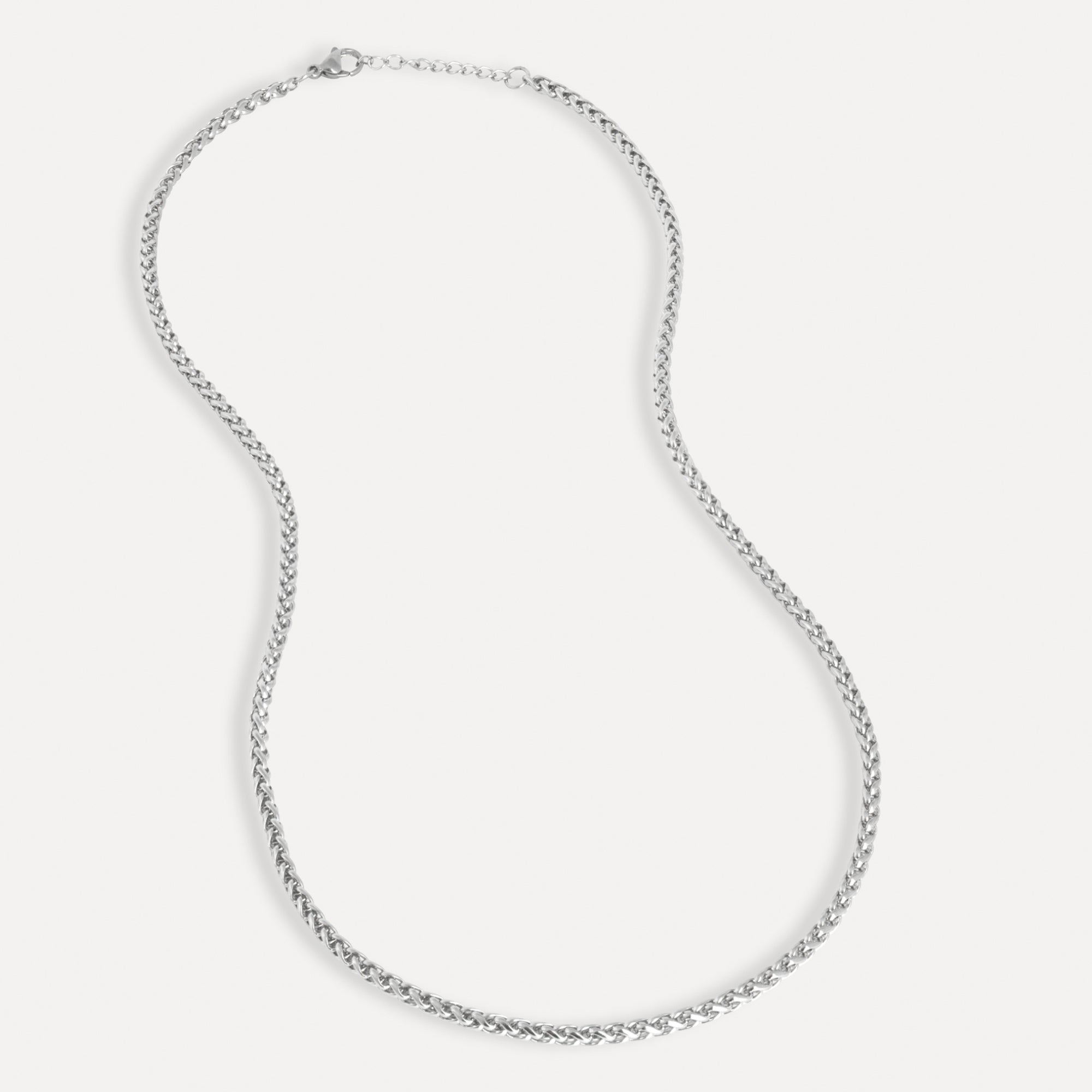 Silver chain necklace on a light gray background
