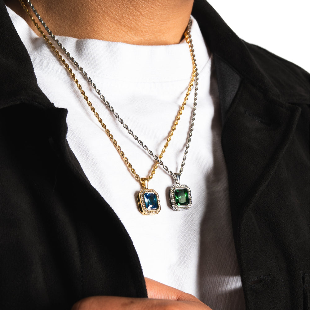 Two necklaces with gemstone pendants worn by a person against a white background