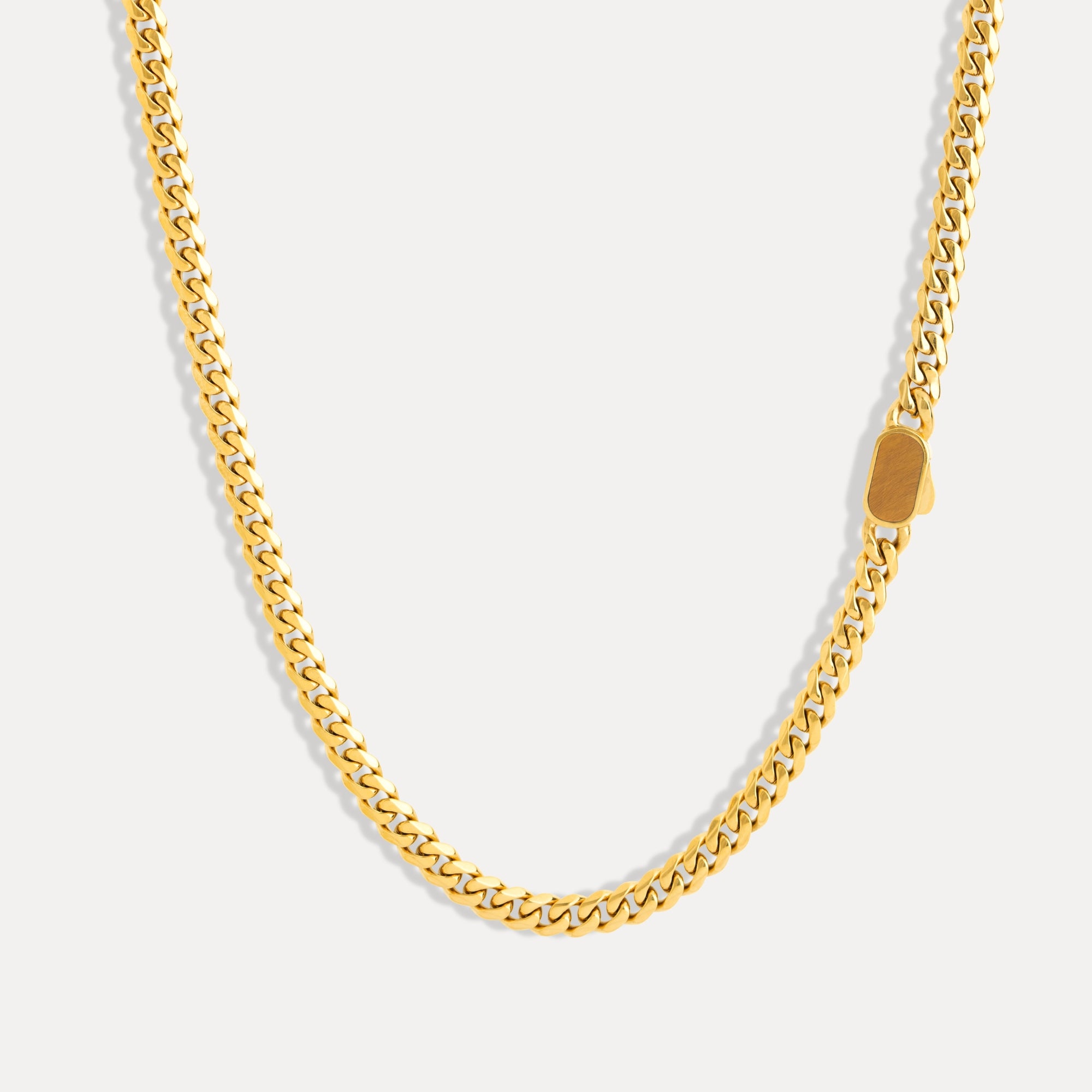 Gold chain necklace on a light gray background