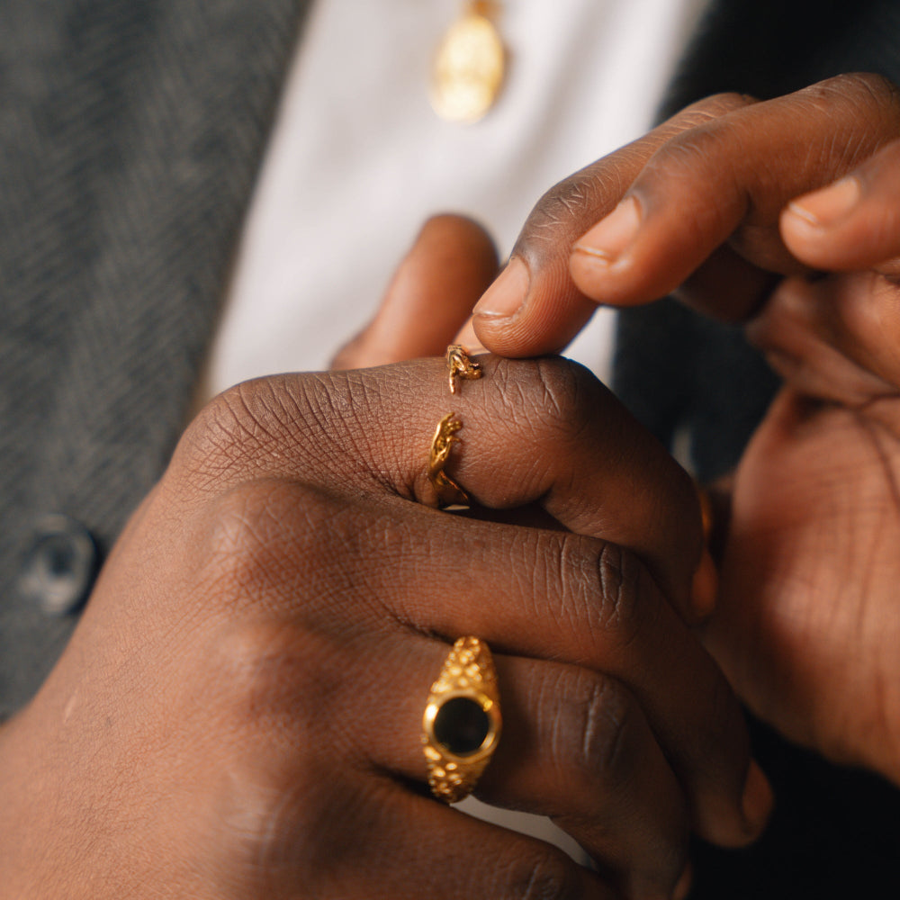 Close-up of hands wearing gold rings with a blurred background