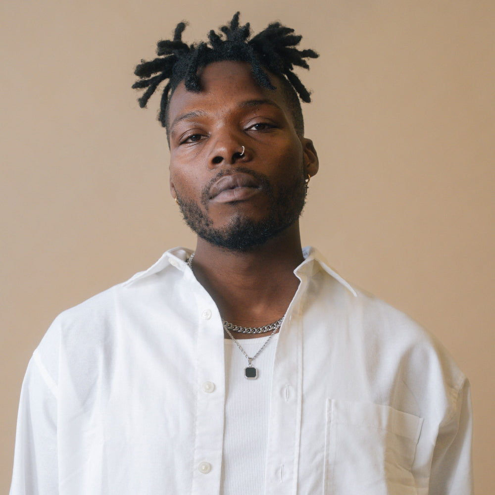 Man wearing a white shirt against a beige background
