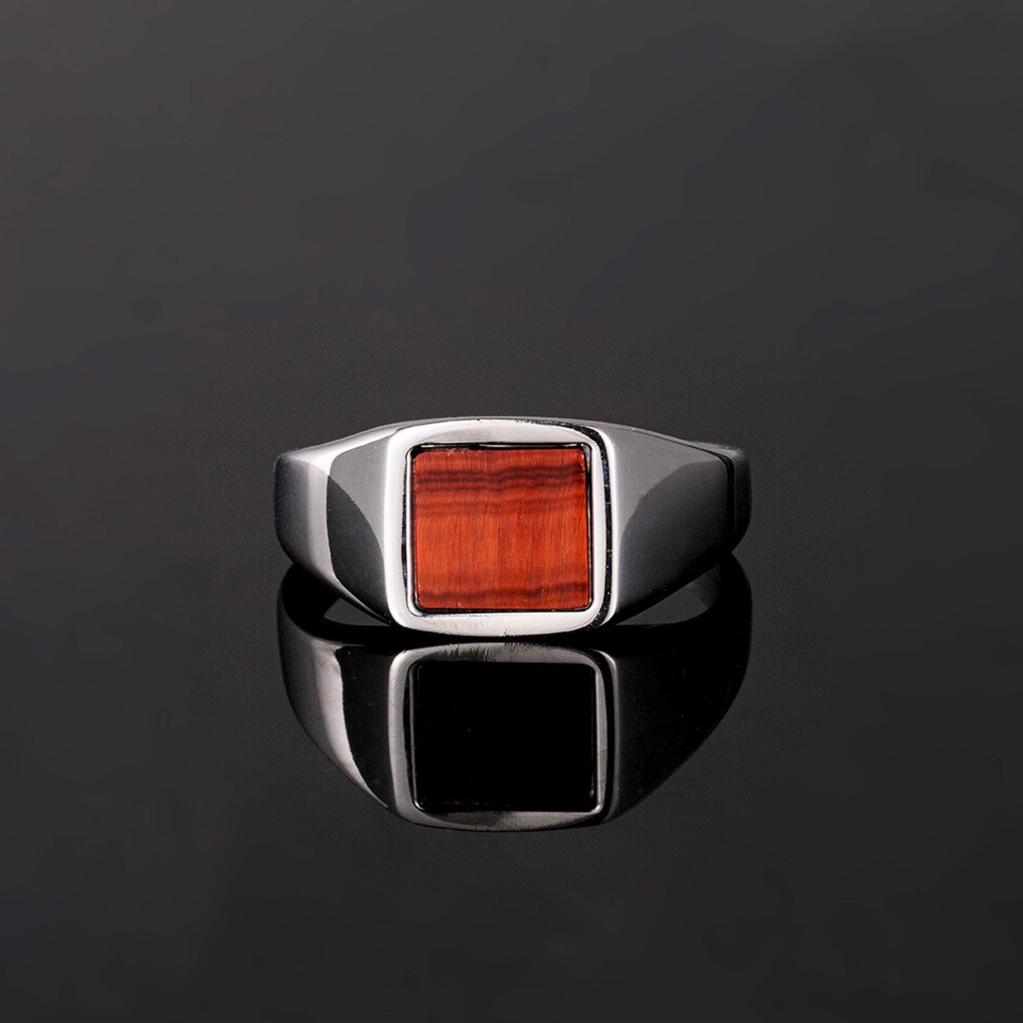 Silver ring with a red stone on a black background