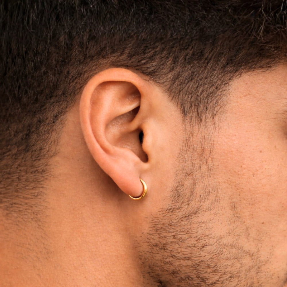 Close-up of an ear with a gold hoop earring