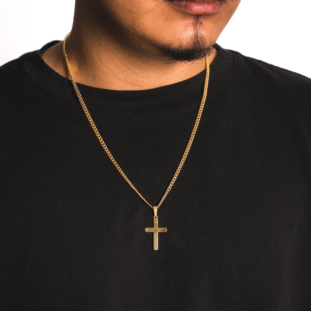 Man wearing a black shirt with a gold chain and cross pendant.