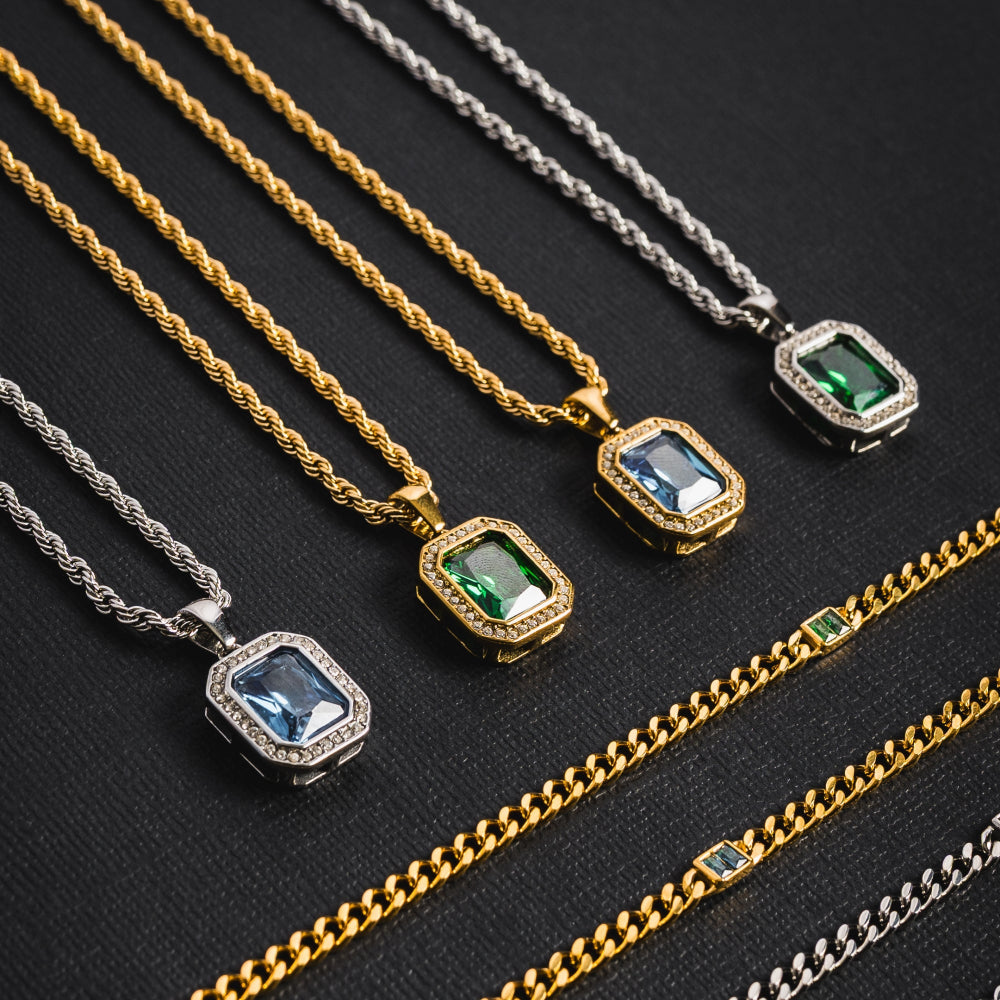 Gold and silver necklaces with gemstone pendants on a black background