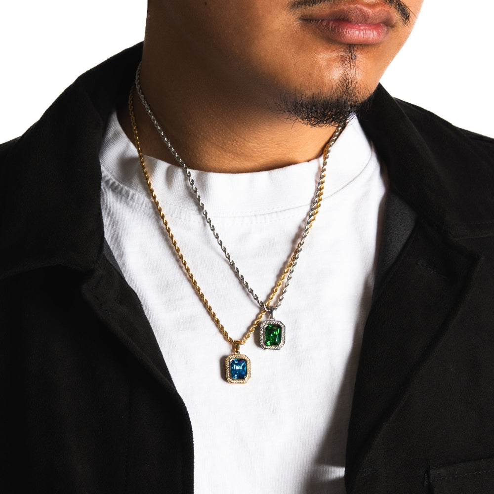 Man wearing two necklaces with pendants on a white background