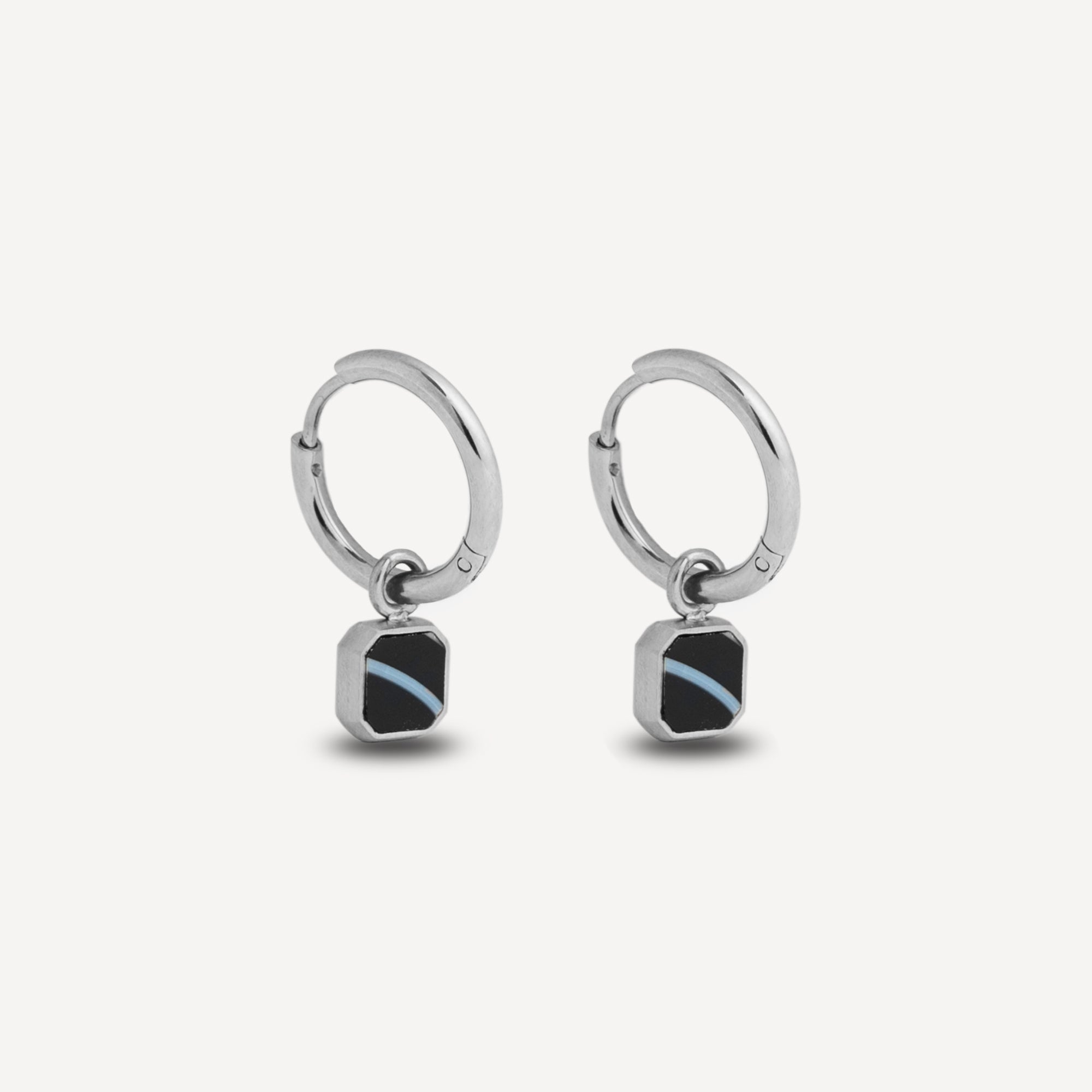 Silver hoop earrings with square black stones on a white background