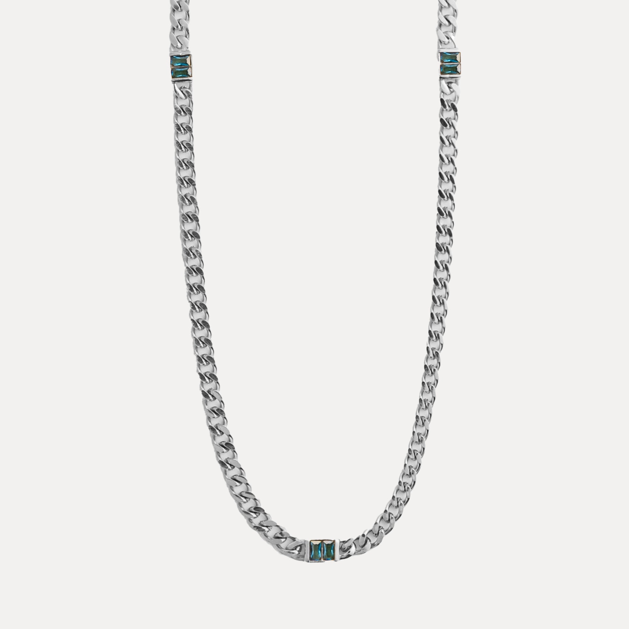 Silver chain necklace with blue accents on a light gray background