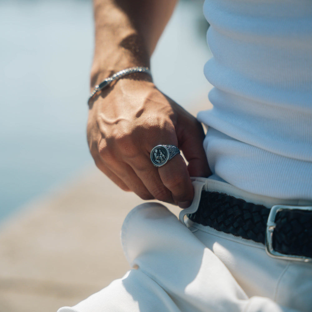 Close-up of a person's hand wearing a ring with a blurred background