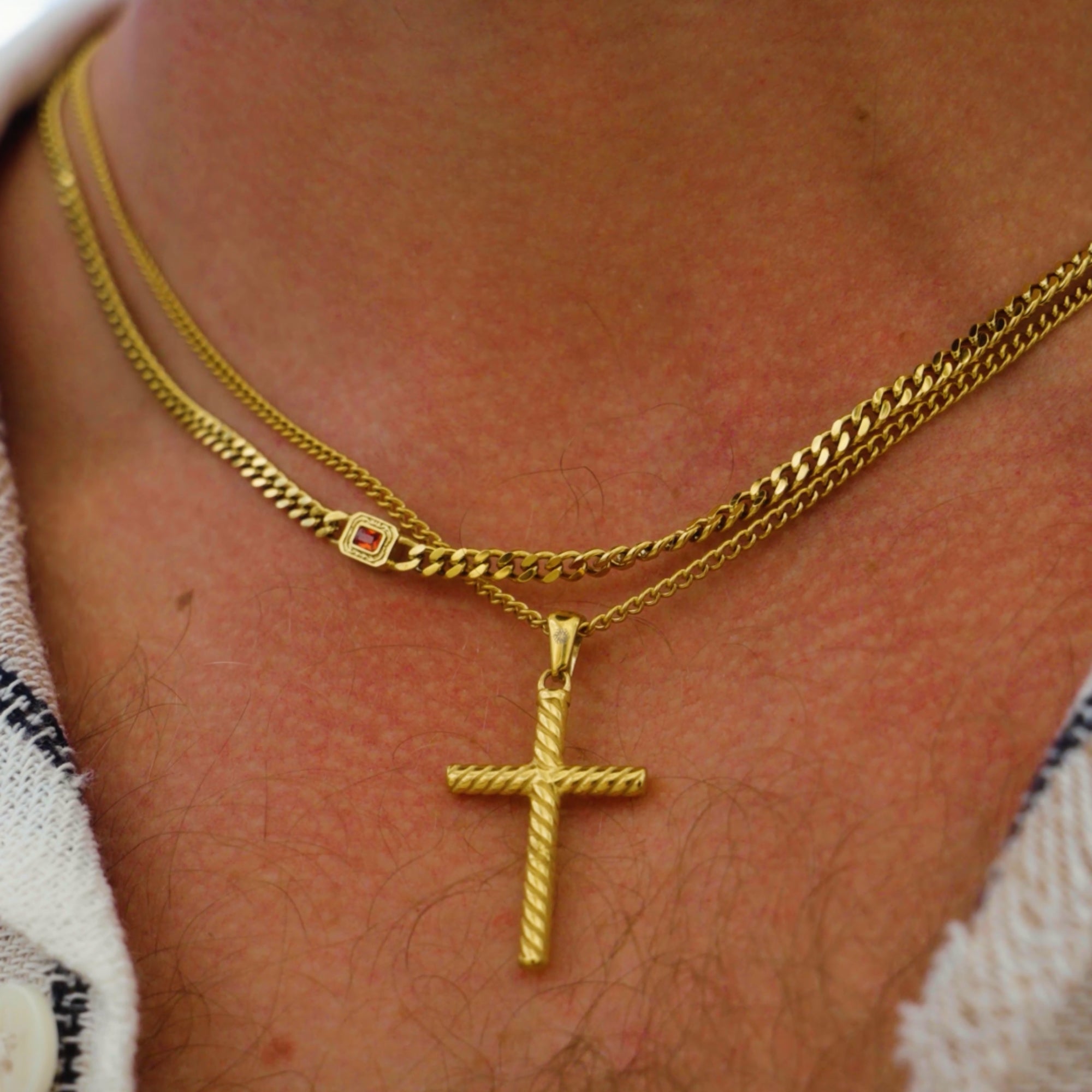 Gold necklace with a cross pendant on a person's neck
