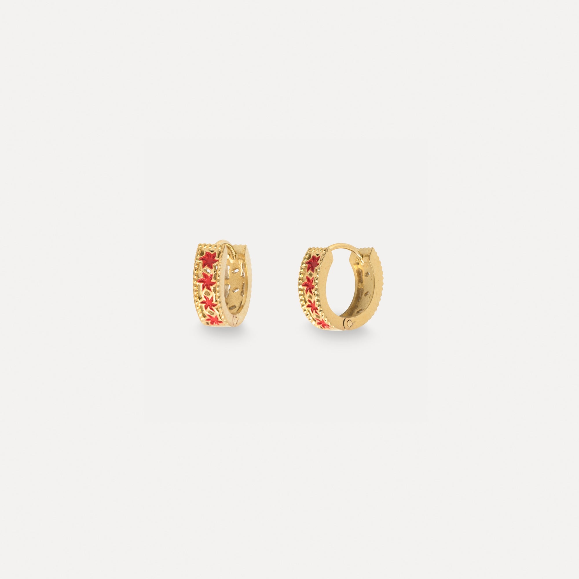 Gold hoop earrings with red gemstones on a white background