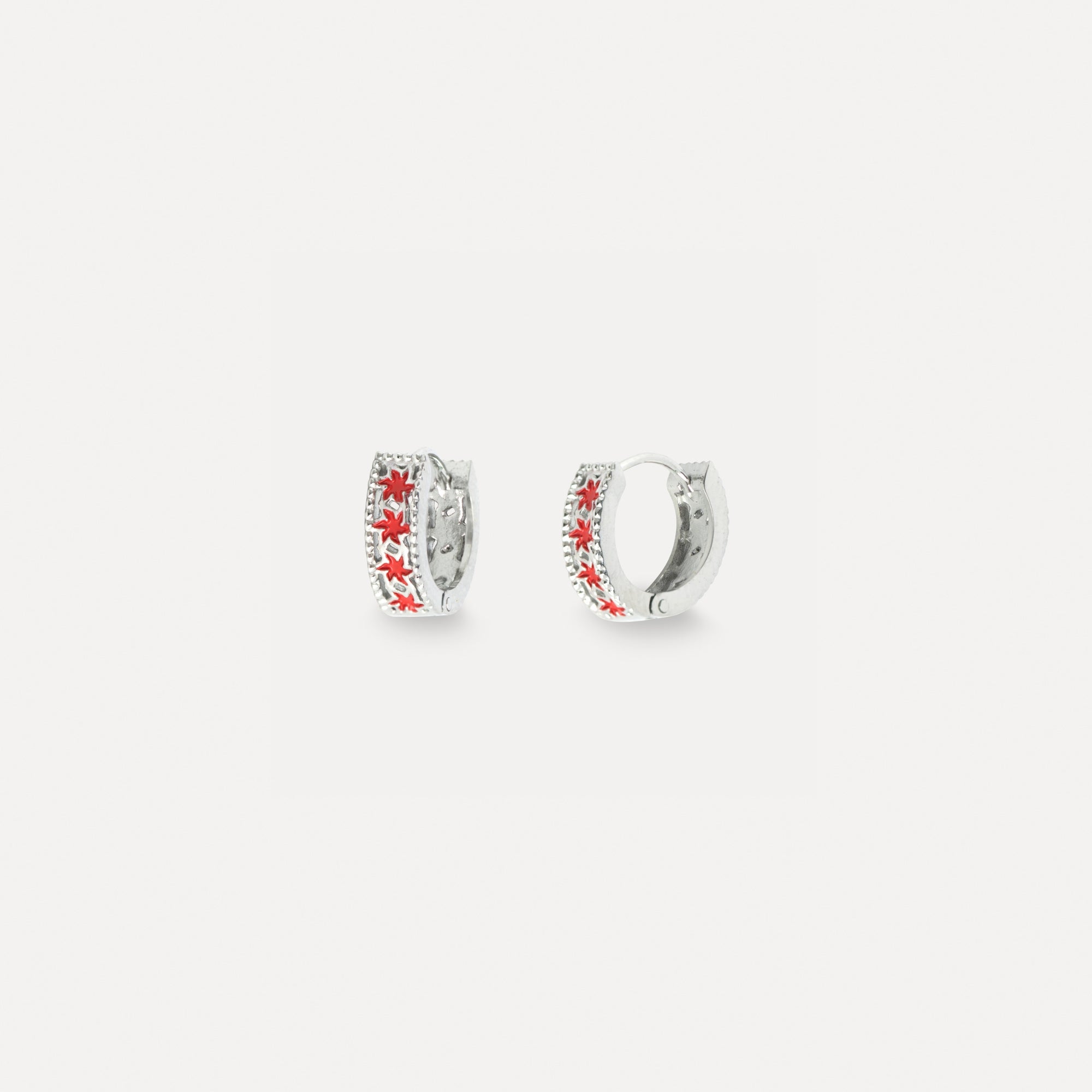 Silver hoop earrings with red floral designs on a white background