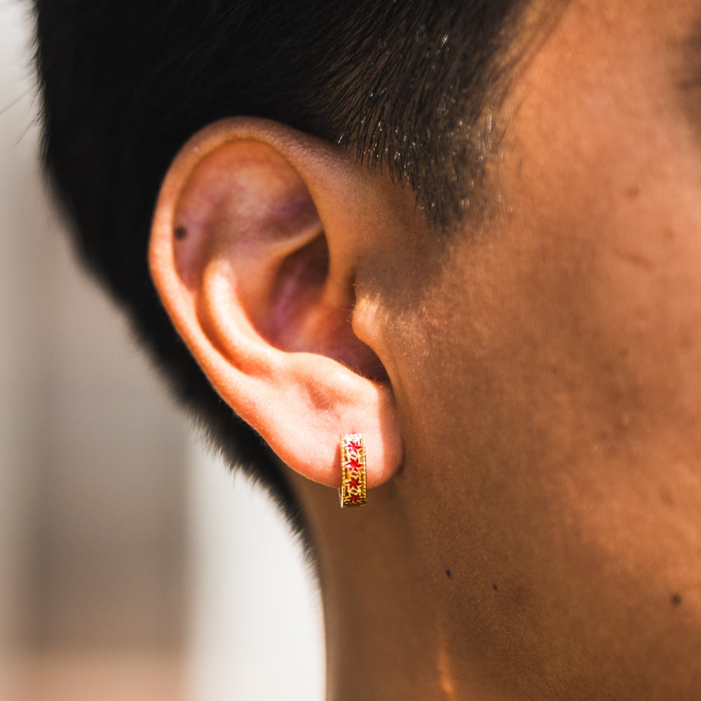 Close-up of an ear wearing a small earring with a blurred background