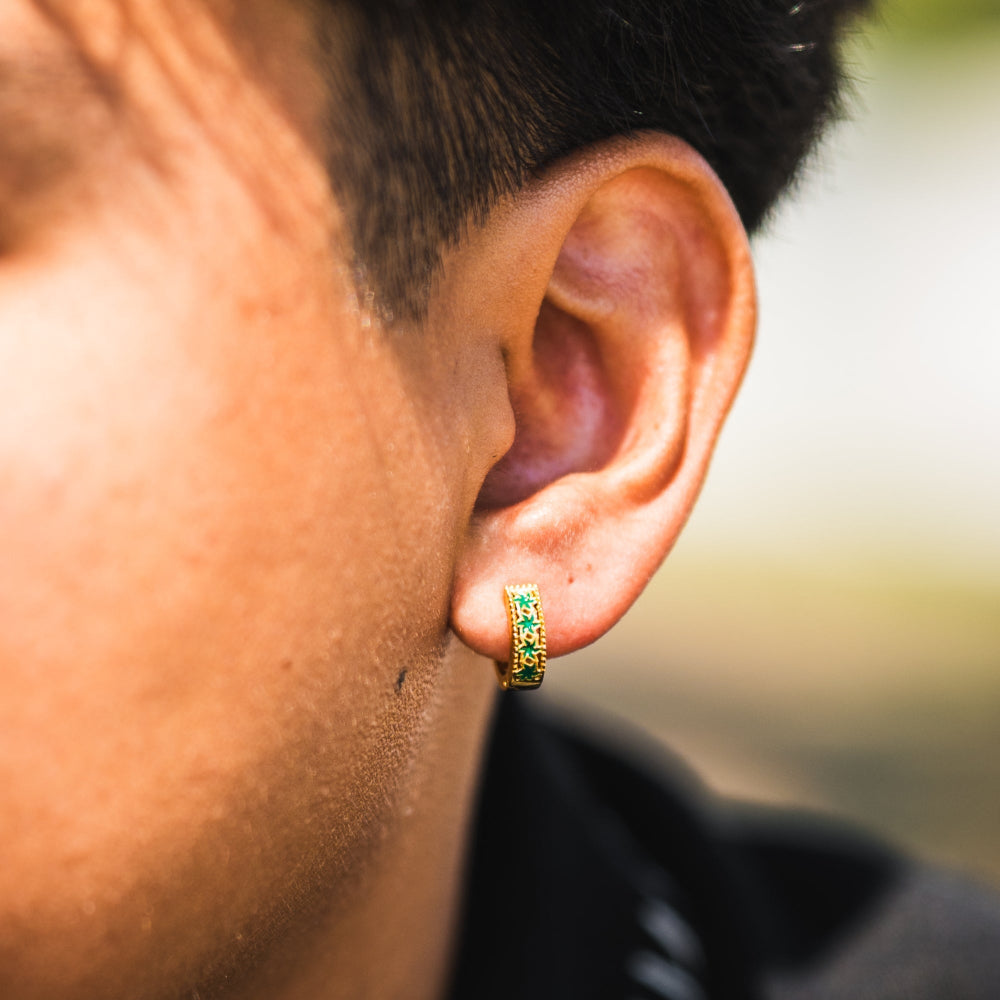 Close-up of an ear wearing a colorful hoop earring with a blurred background
