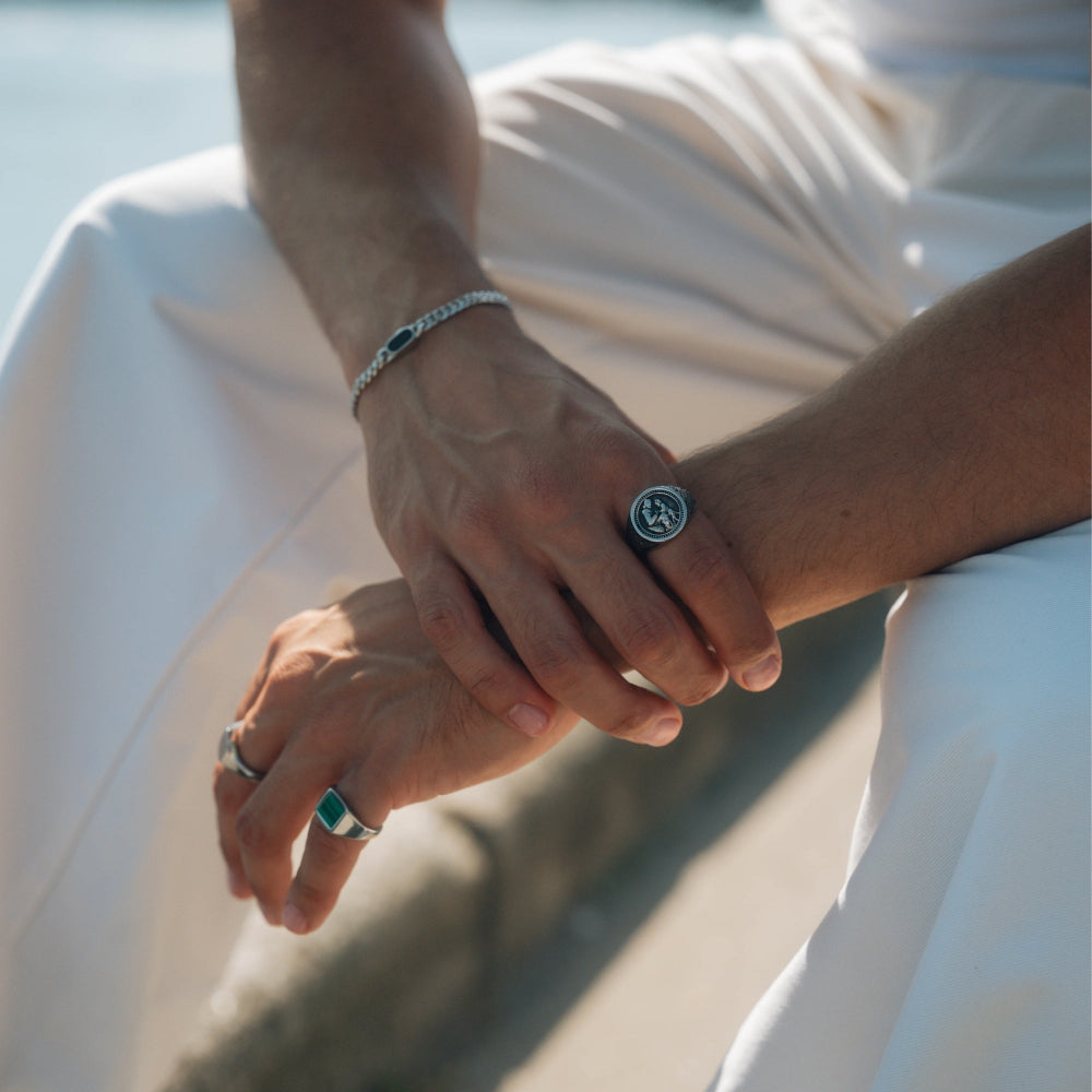 Close-up of hands with rings and bracelets against a blurred natural background