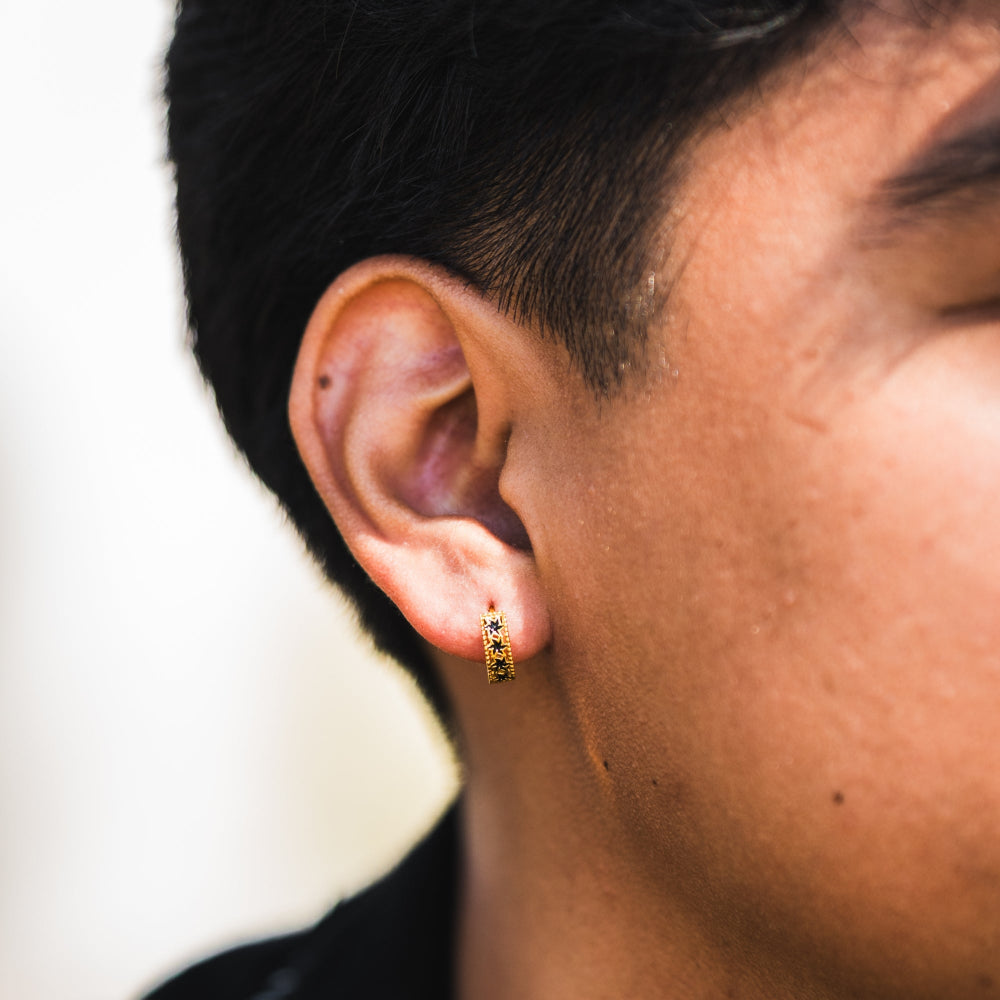 Close-up of an ear wearing a small earring with a blurred background