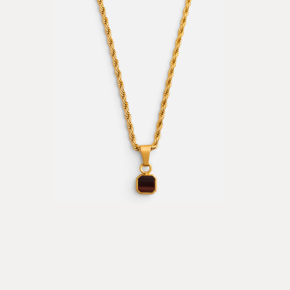 Gold necklace with a brown pendant on a white background