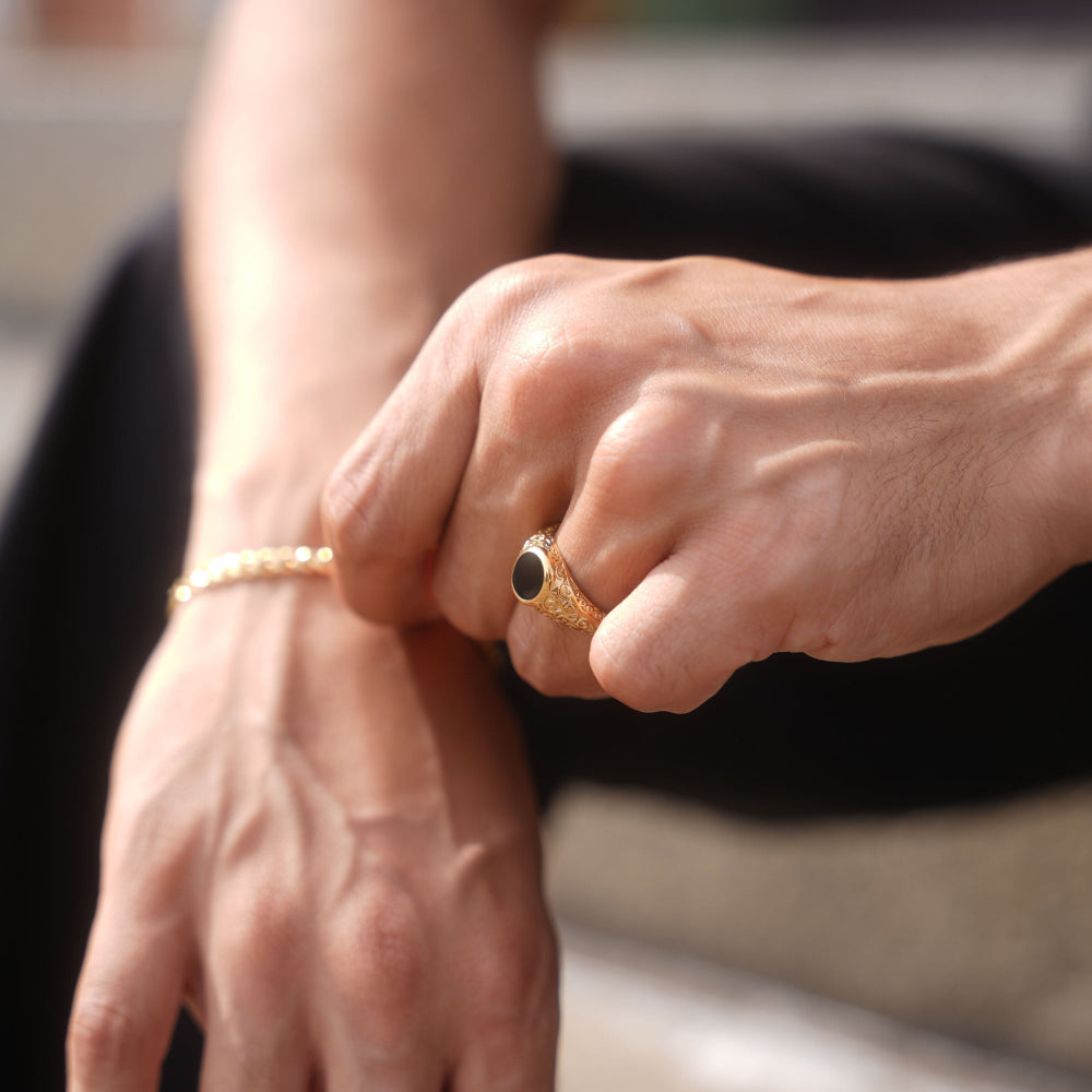 Close-up of hands with gold ring and bracelet on a blurred background
