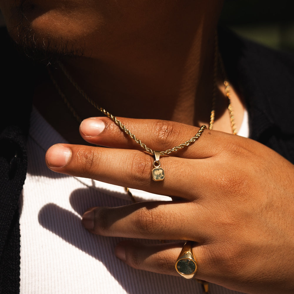 Close-up of a hand wearing gold jewelry with a blurred background