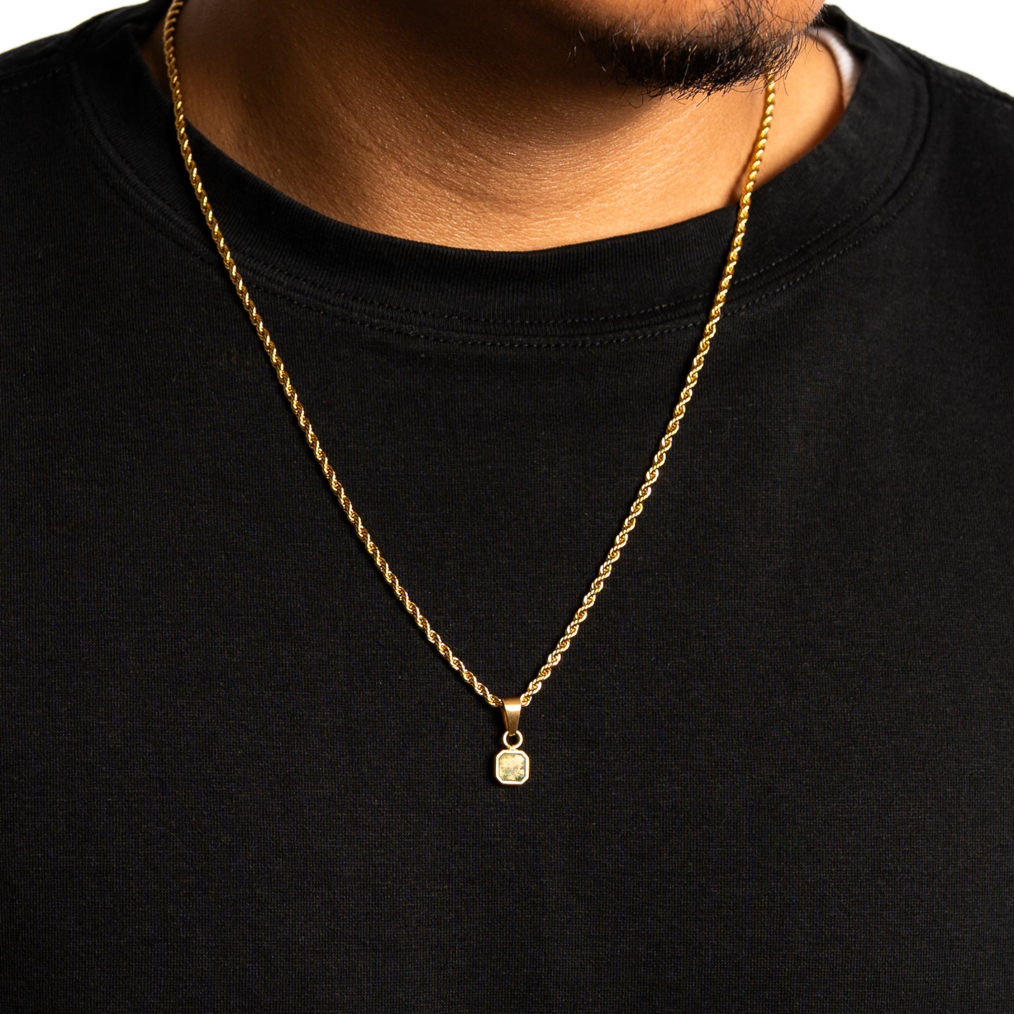 Gold necklace with a pendant on a black shirt