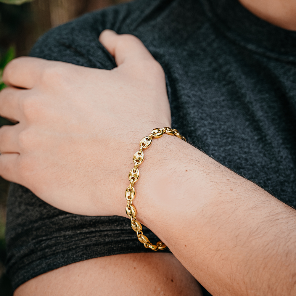 Gold chain bracelet on a wrist with a blurred background