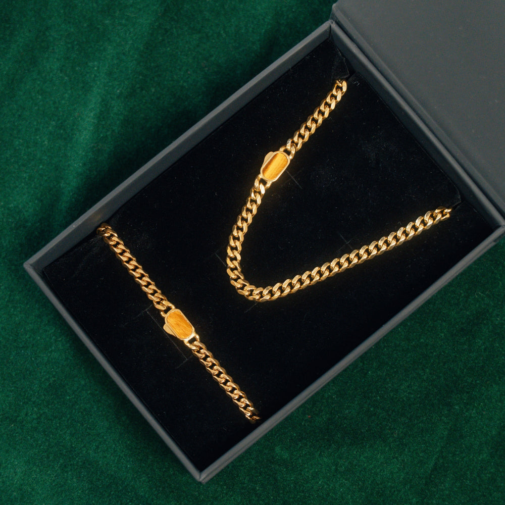 Gold chain necklace in a black jewelry box on a green background
