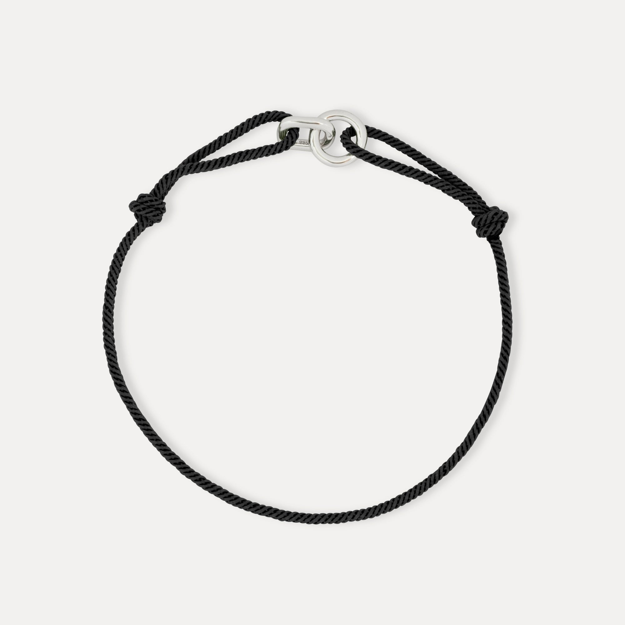 Black cord bracelet with silver clasp on a white background