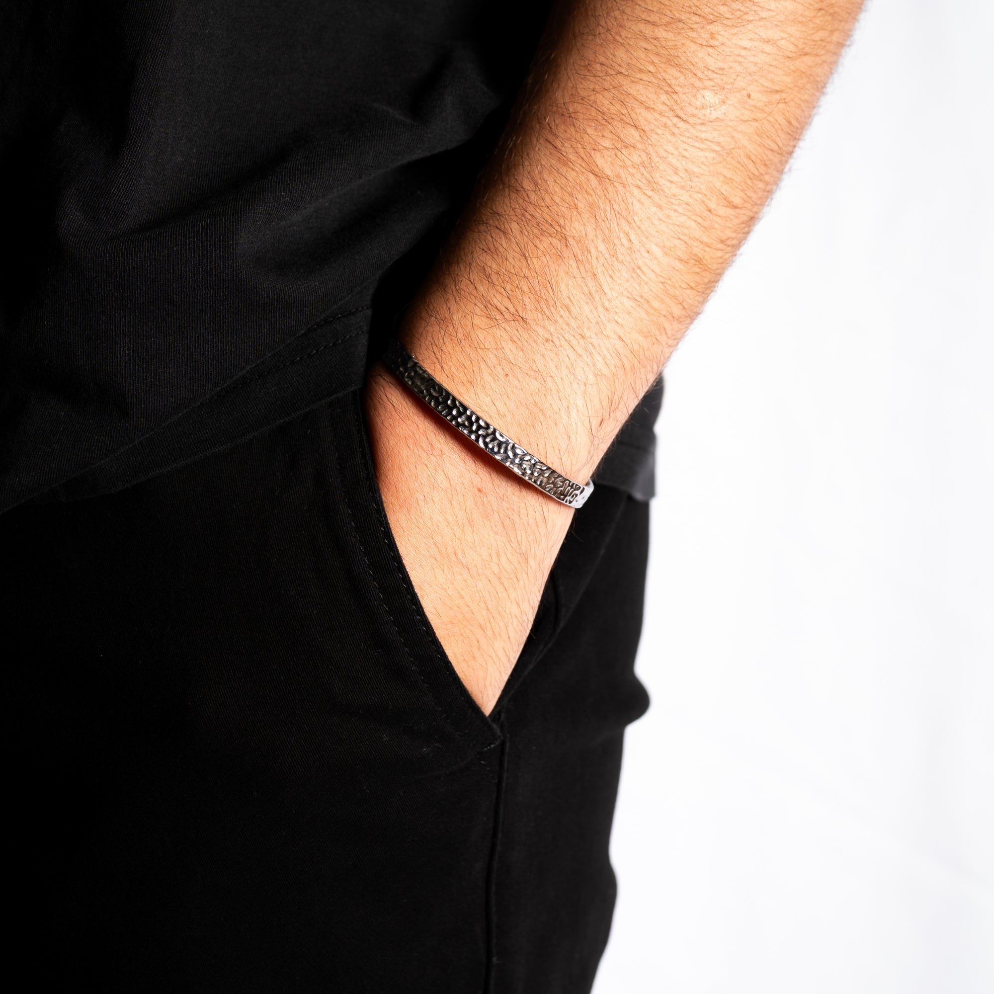 Person wearing a black bracelet with a white background