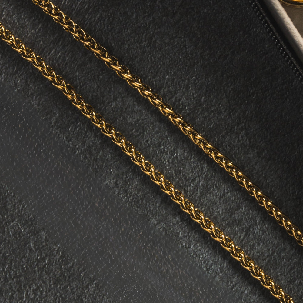 Gold chain on a black textured surface