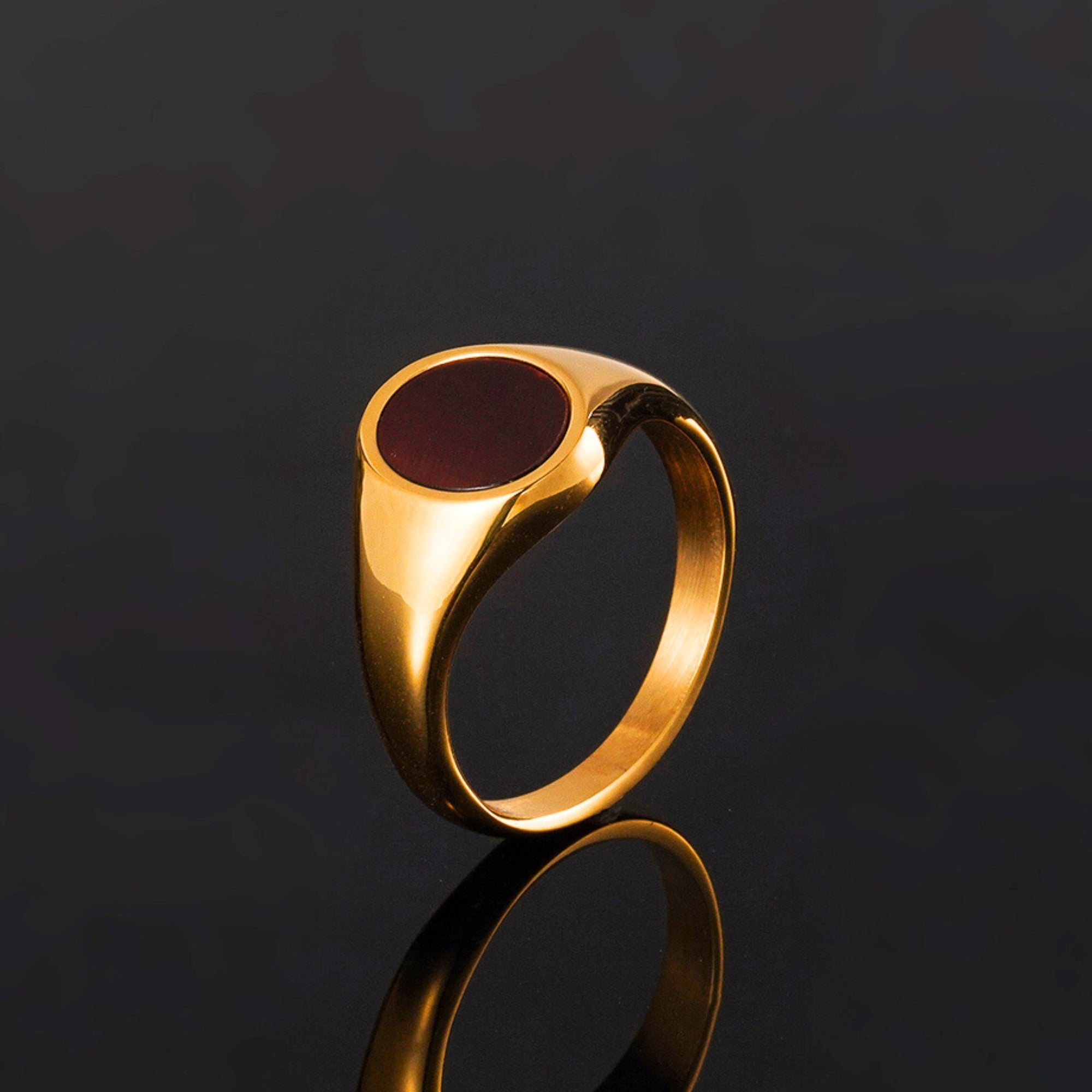 Gold ring with a red stone on a black background