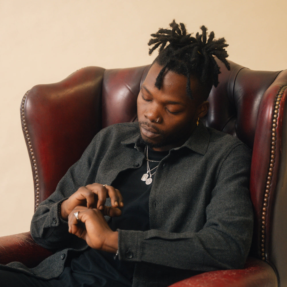 Man sitting in a leather chair wearing a dark gray shirt.