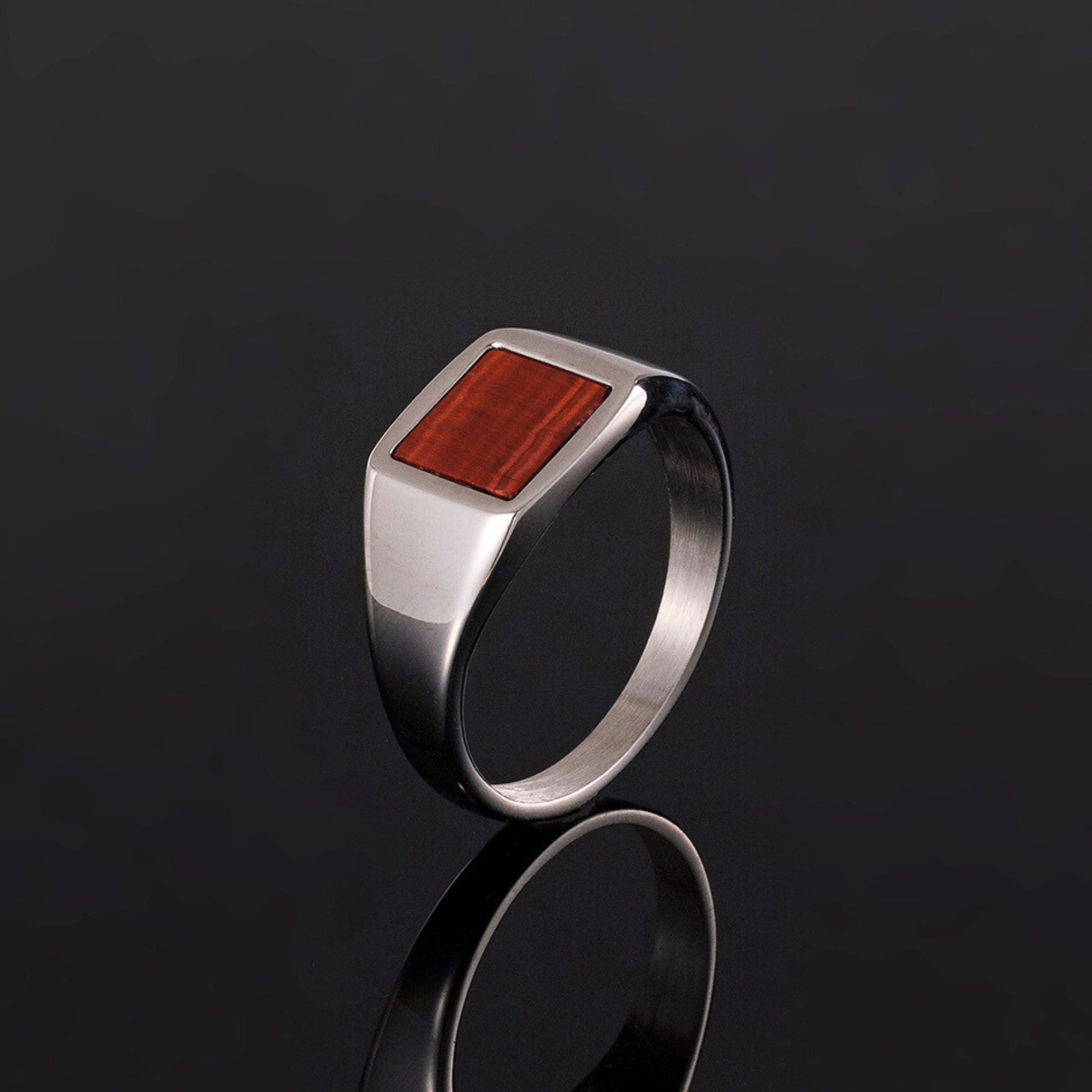 Silver ring with a red stone on a black background