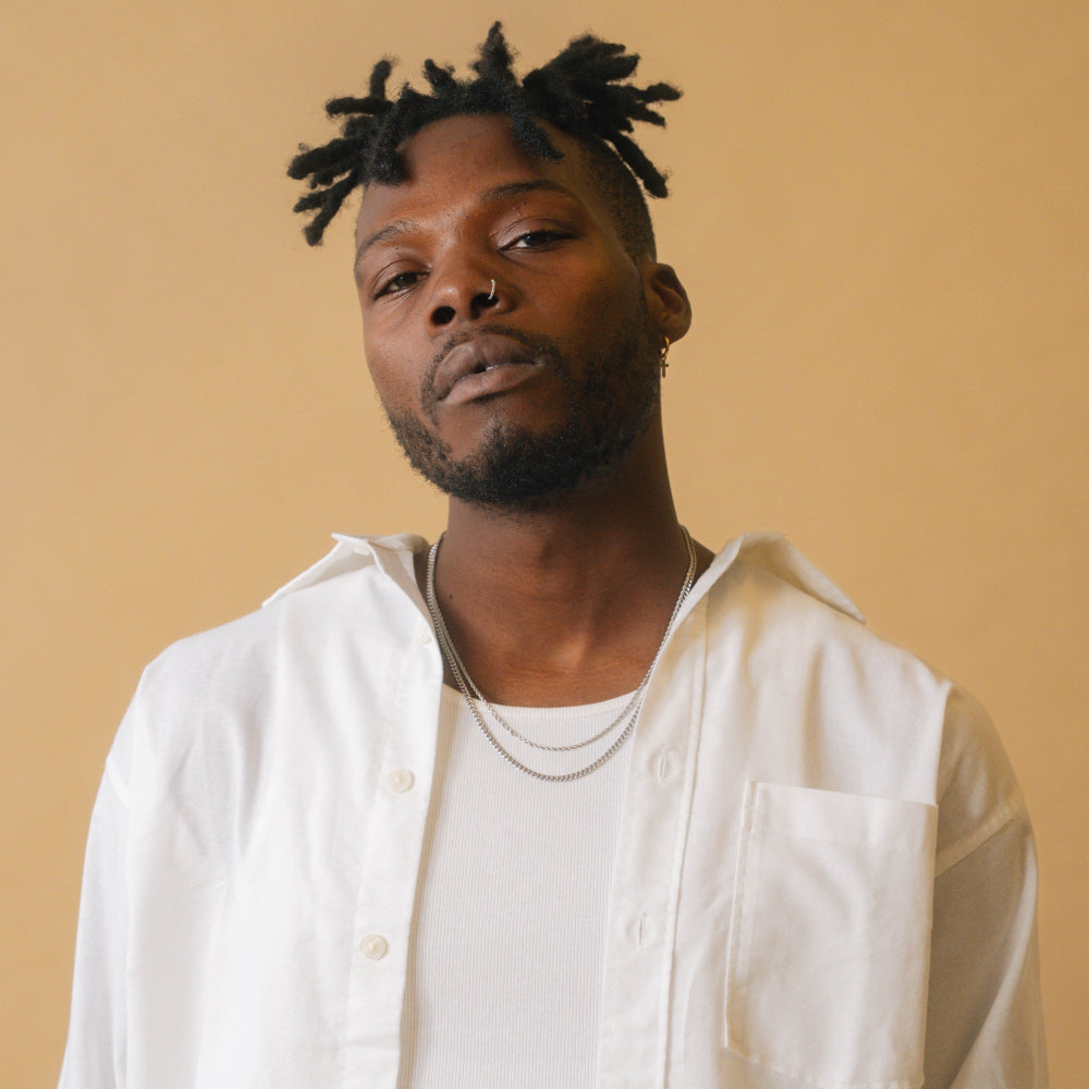 Man wearing a white shirt against a beige background