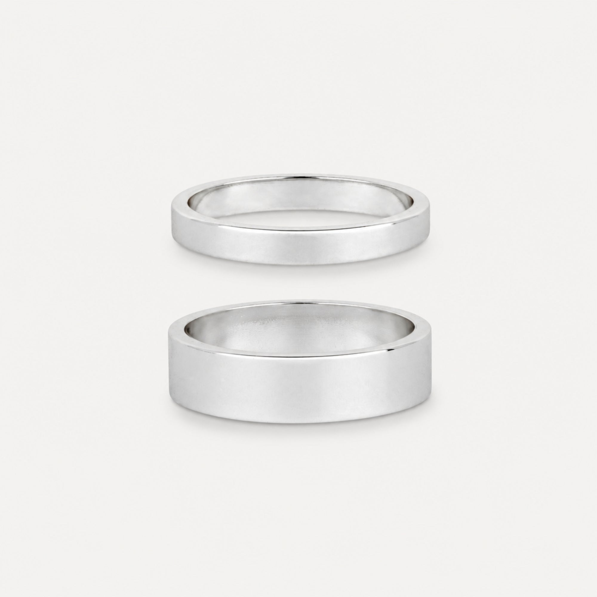 Two silver rings on a light gray background