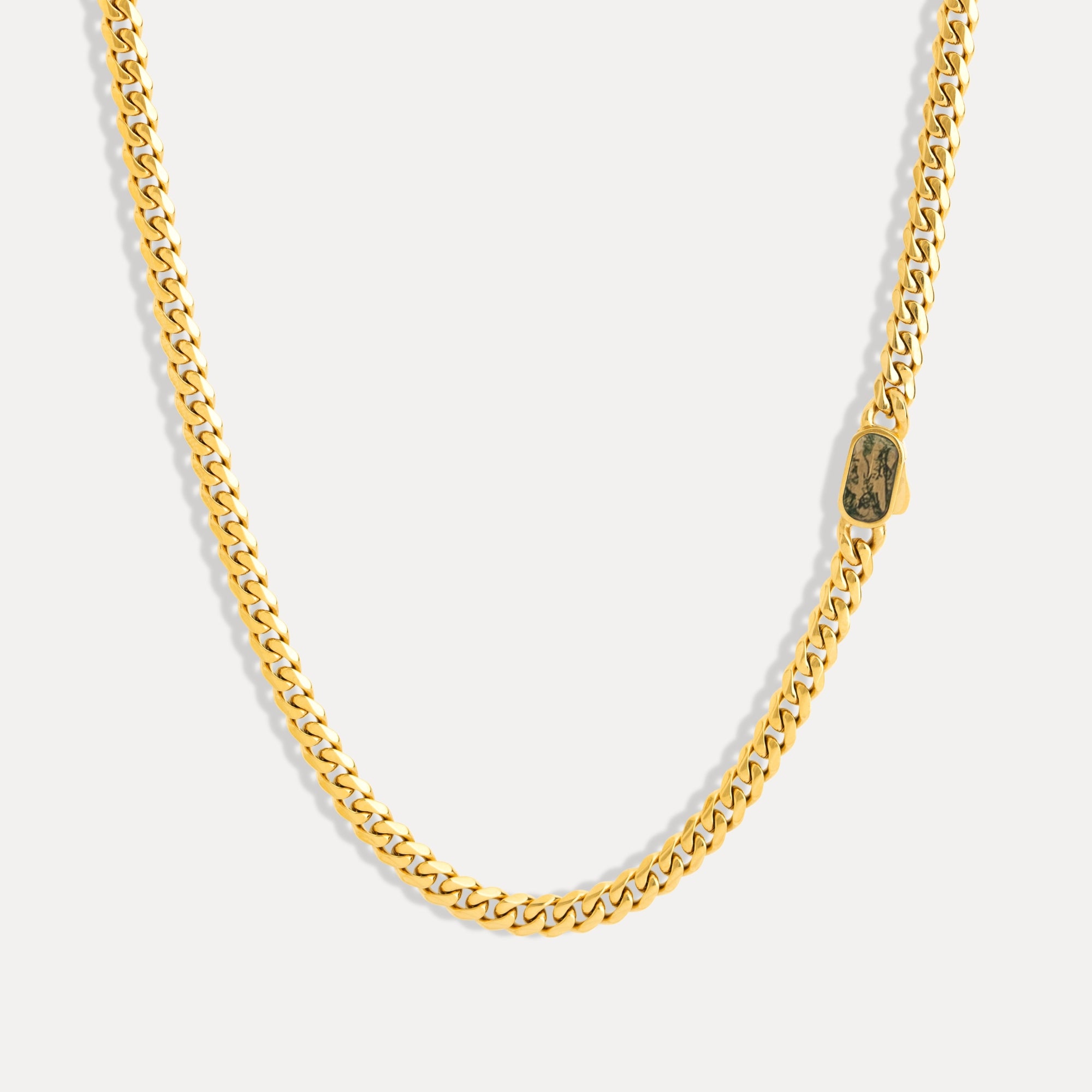 Gold chain necklace on a light gray background