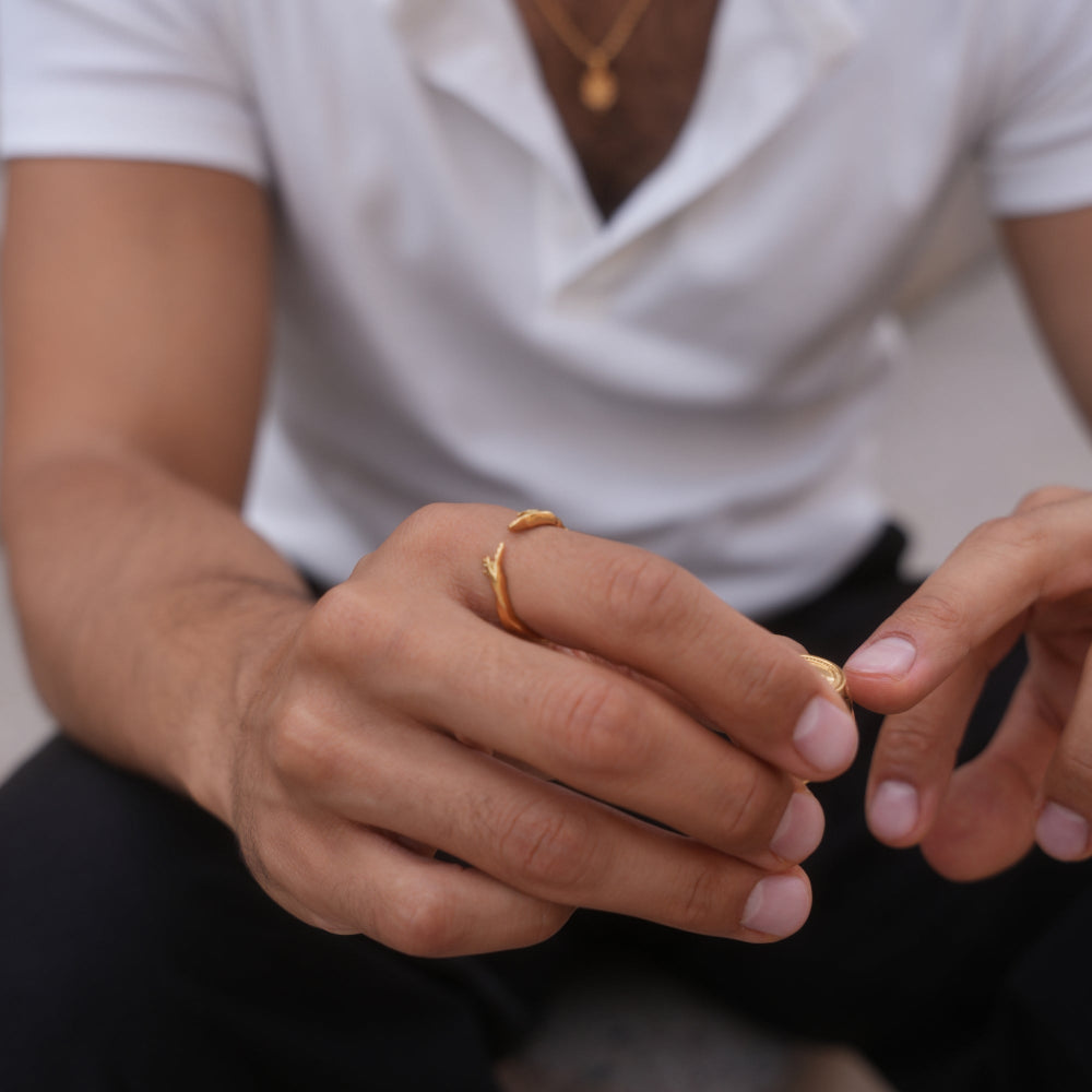 Close-up of two hands wearing gold rings with a blurred background