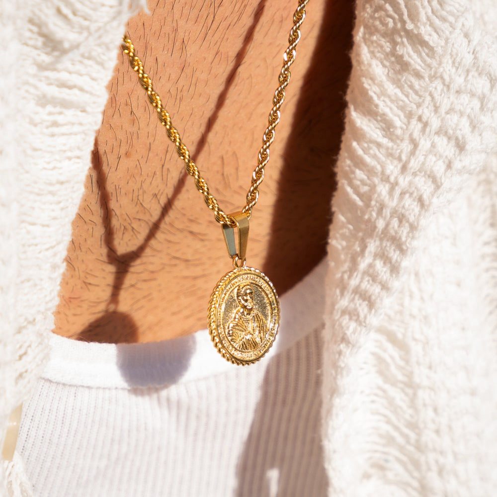 Gold necklace with a pendant on a textured surface