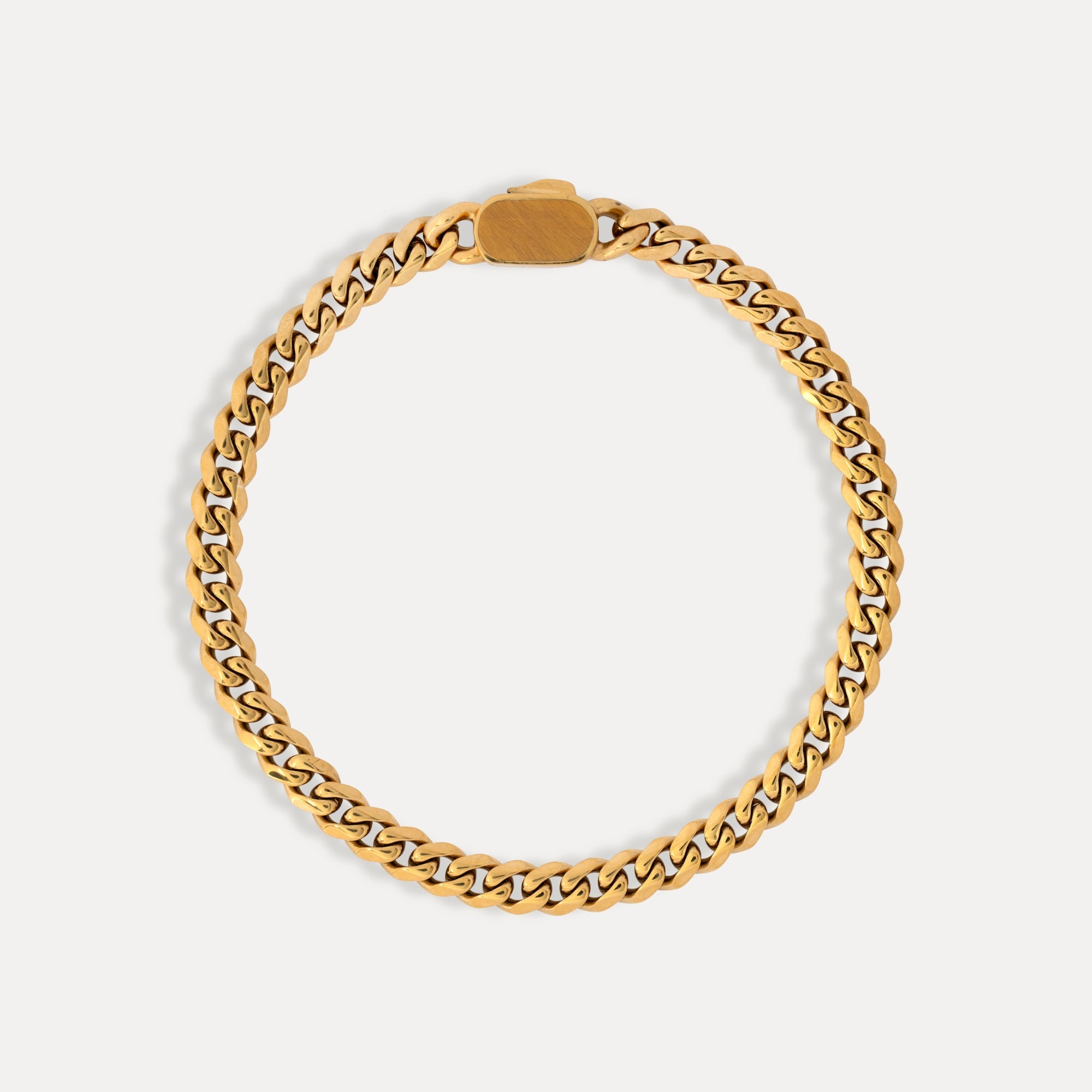 Gold chain bracelet on a light gray background