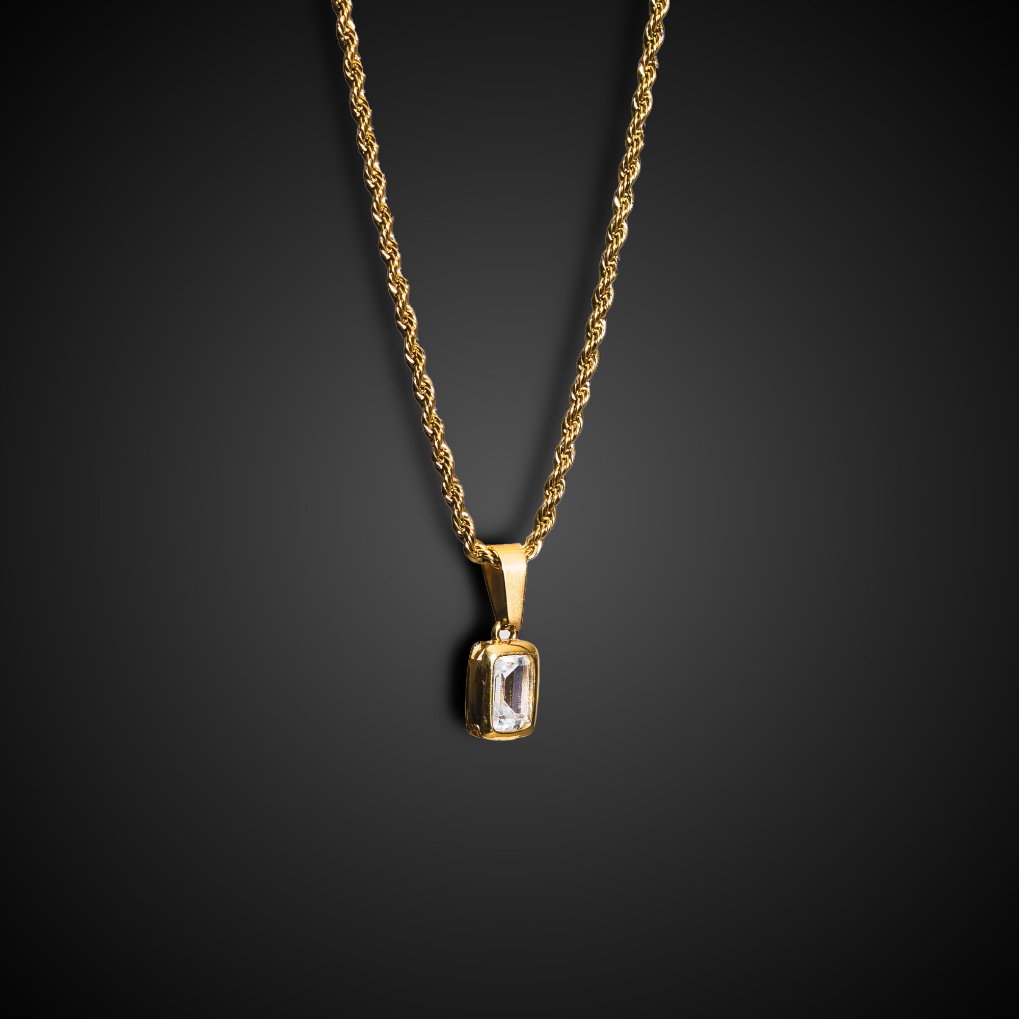 Gold necklace with a pendant on a black background