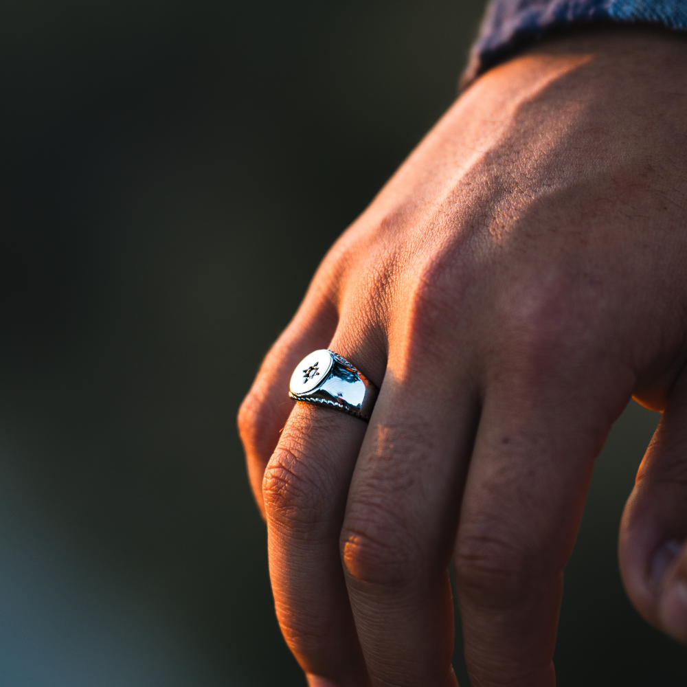 Hand wearing a ring with a blurred background