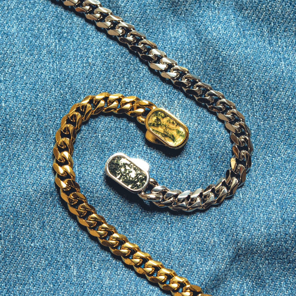 Gold and silver chain bracelet on a blue denim background