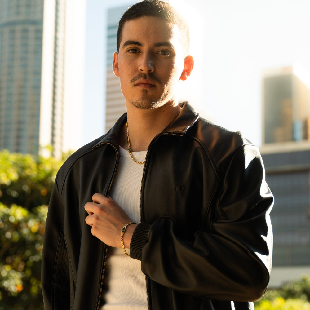 Man wearing a dark jacket with a cityscape in the background