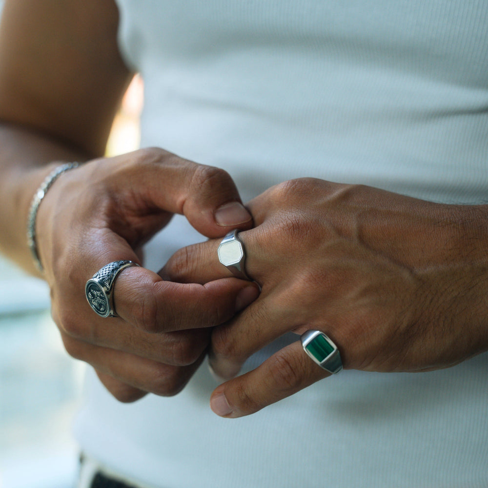 Close-up of two hands with rings on a blurred background