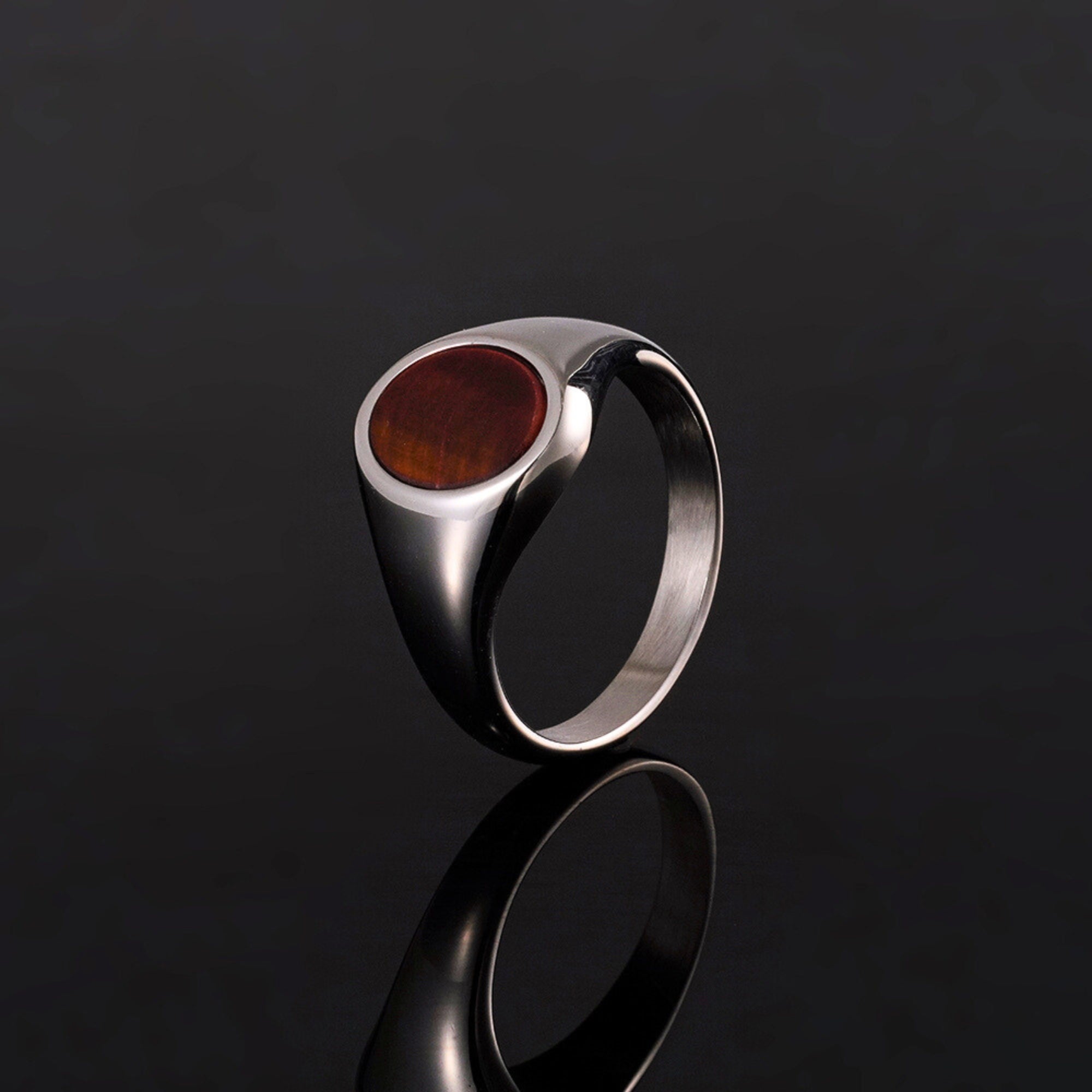 Silver ring with a red stone on a black background