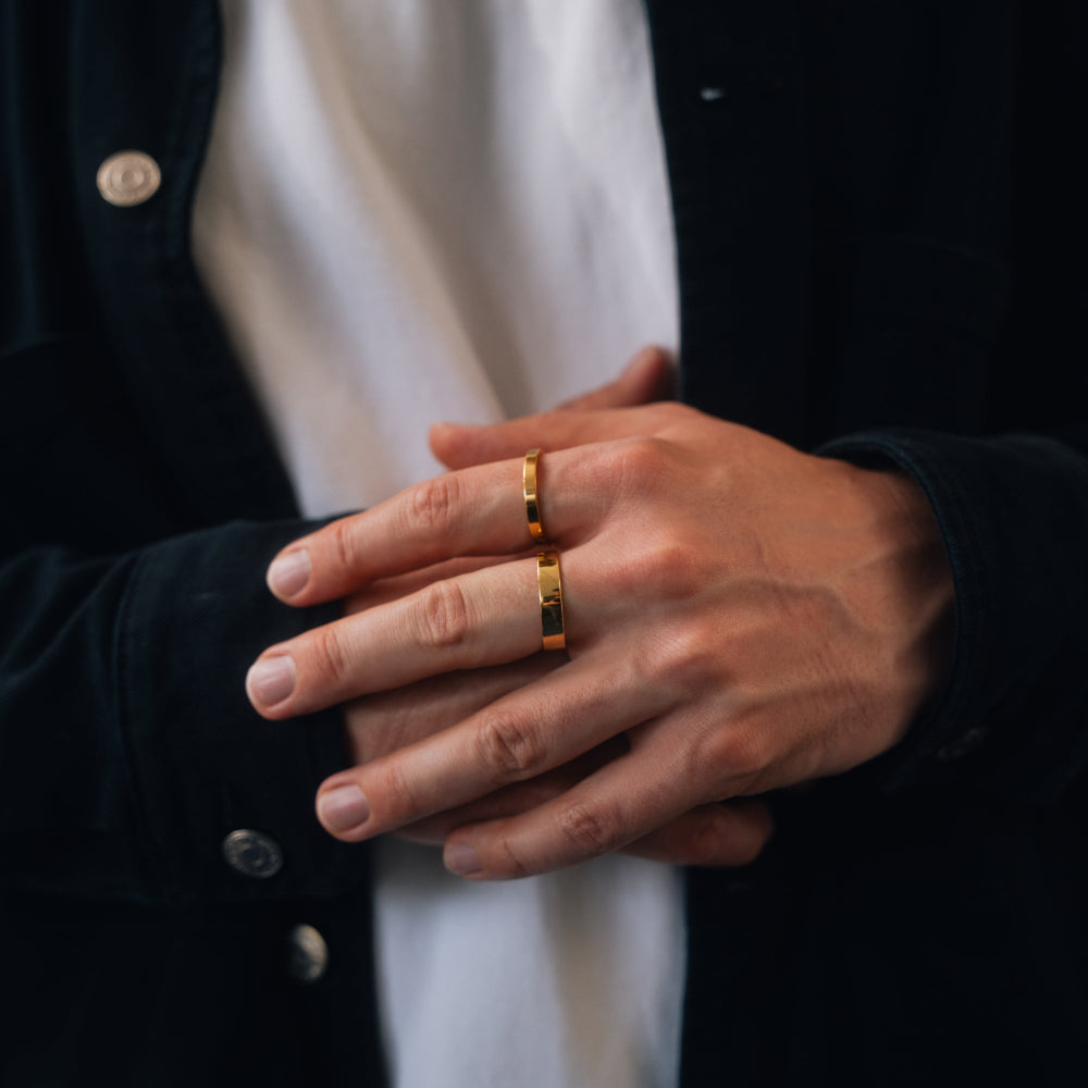 Close-up of hands wearing gold rings with a blurred background