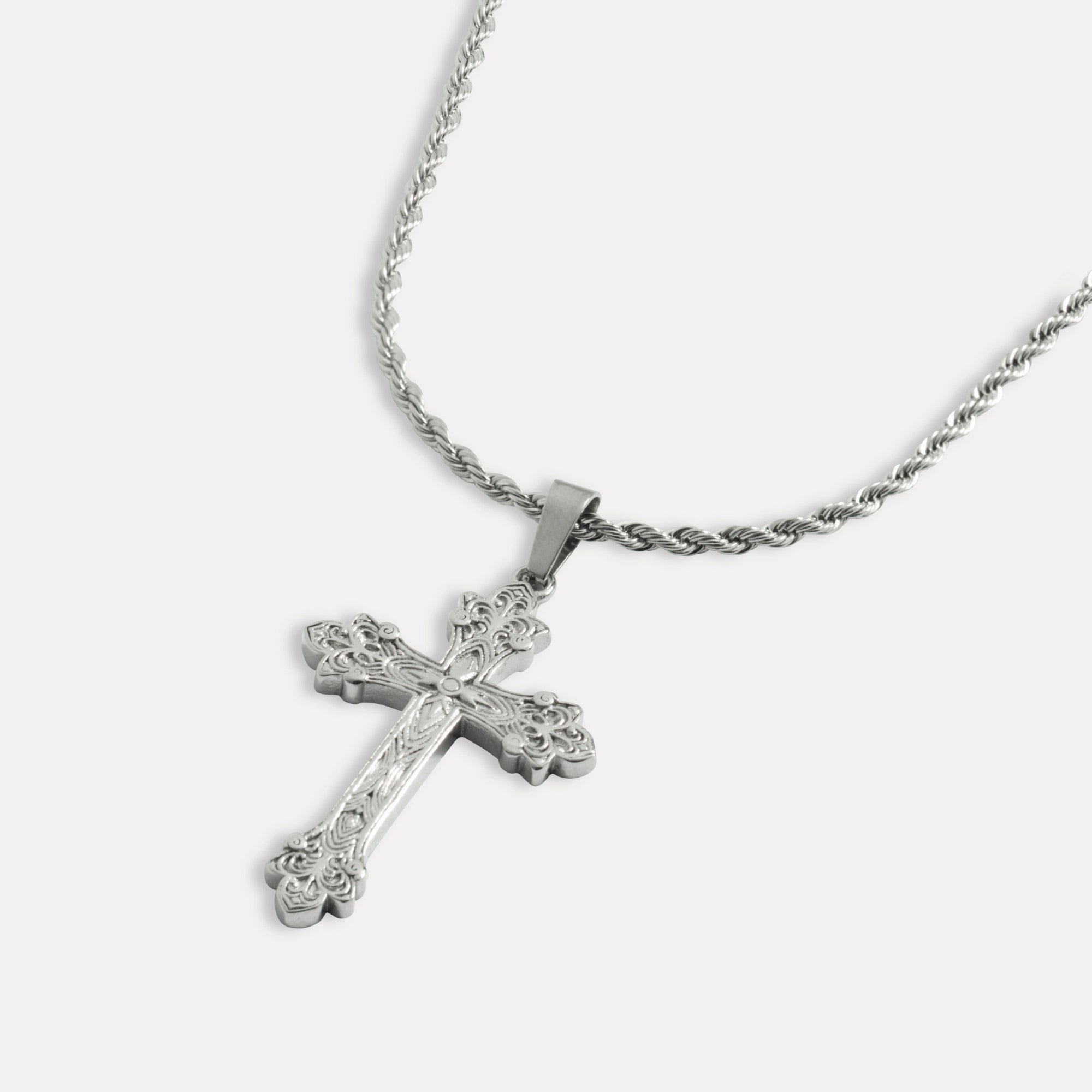A silver-colored vintage cross pendant necklace with a twisted rope chain.