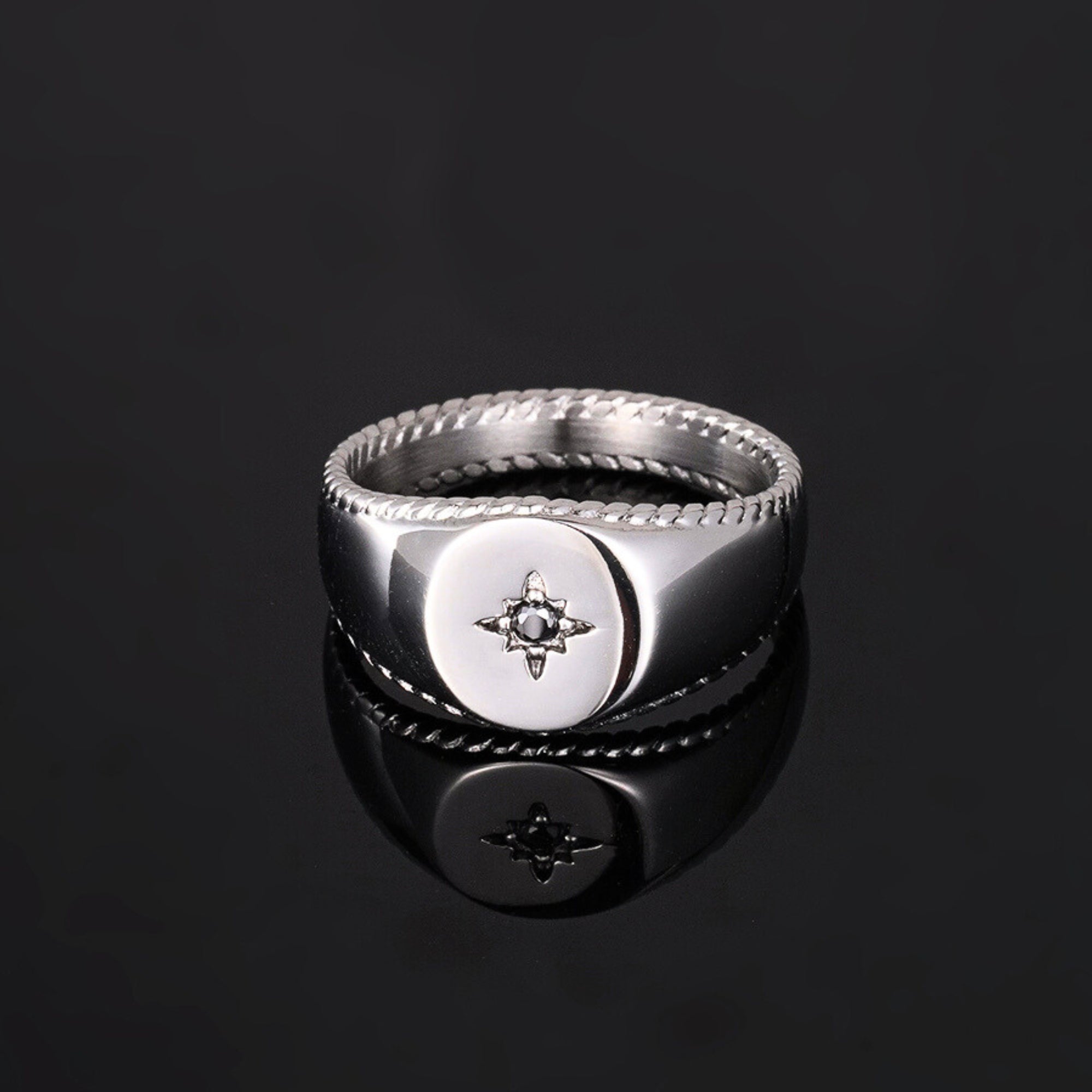 Silver ring with a star design on a black background