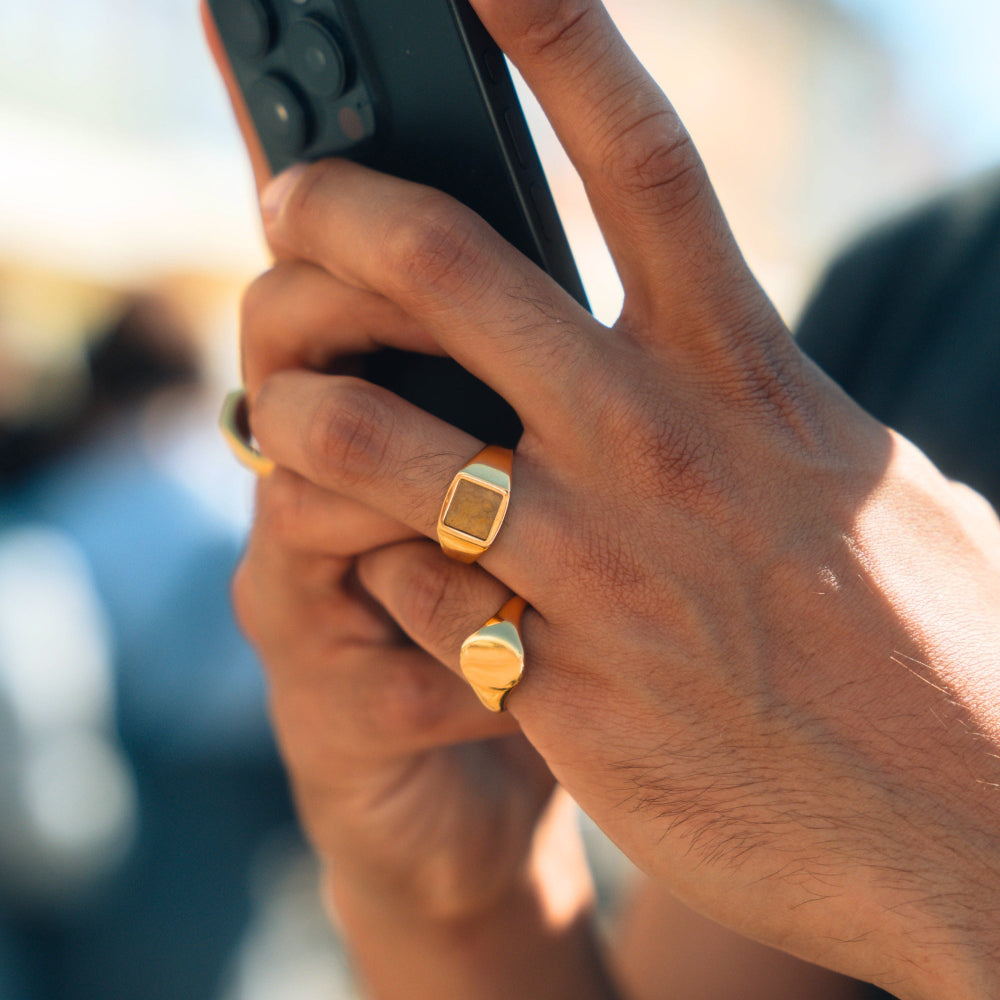 Close-up of hands holding a smartphone with a blurred outdoor background